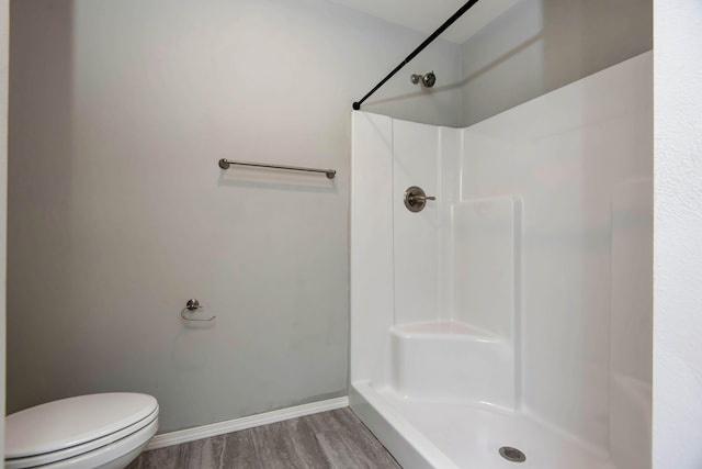 bathroom featuring wood-type flooring, walk in shower, and toilet