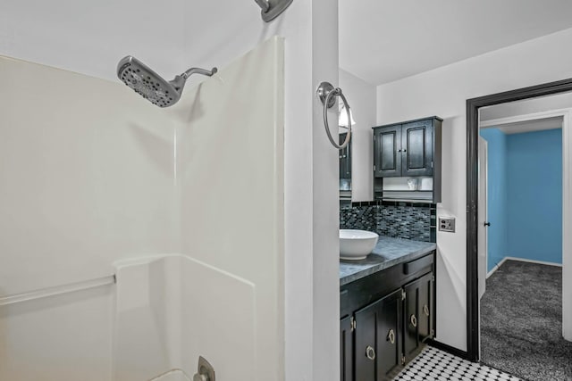 bathroom featuring vanity, a shower, and backsplash