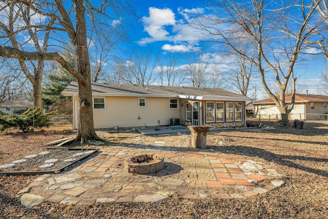 back of house with an outdoor fire pit, a sunroom, and a patio area