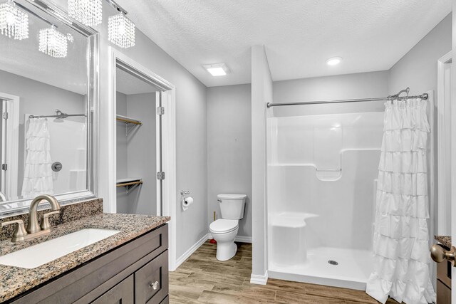 1989 Crawford St, West Plains, MO 65775 - bathroom with hardwood / wood-style flooring, vanity, walk in shower, toilet, and a textured ceiling