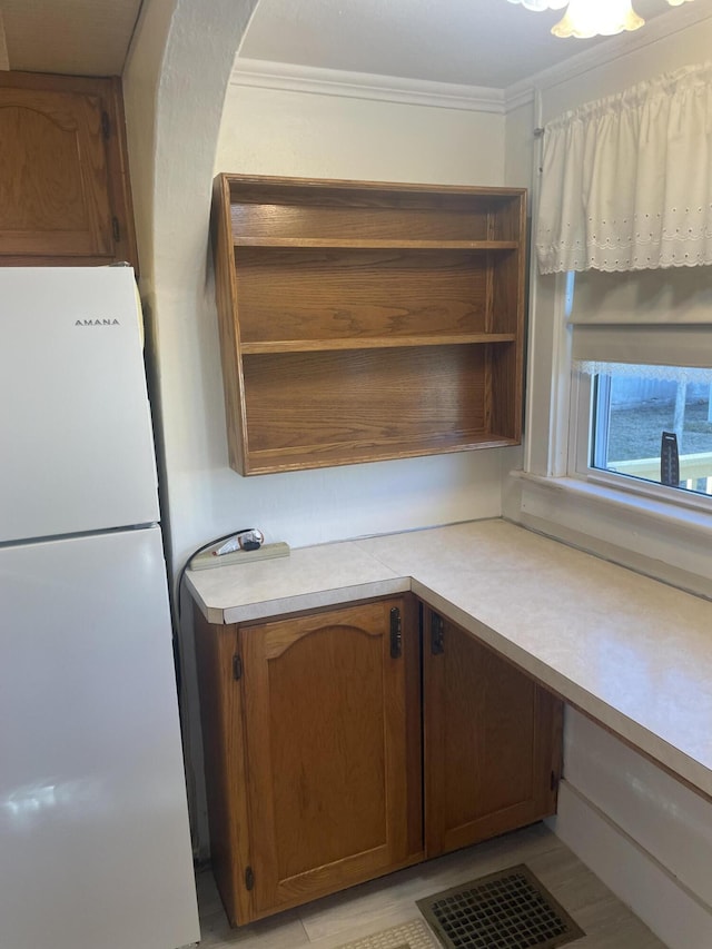 kitchen featuring crown molding and white fridge