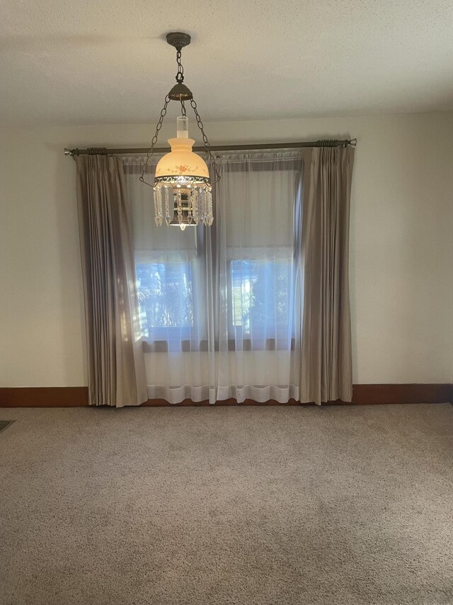 unfurnished room featuring carpet and a textured ceiling