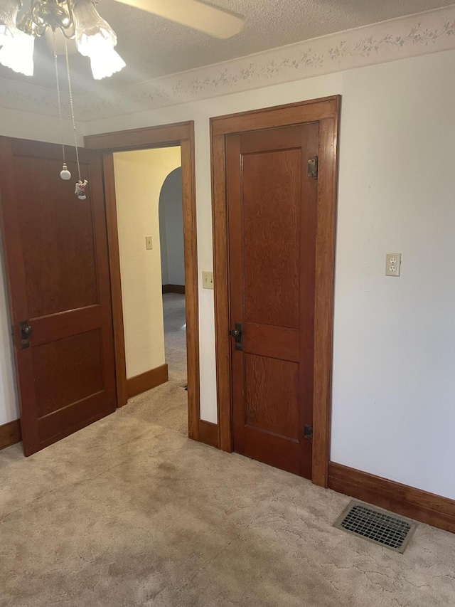 interior space with light colored carpet and a textured ceiling