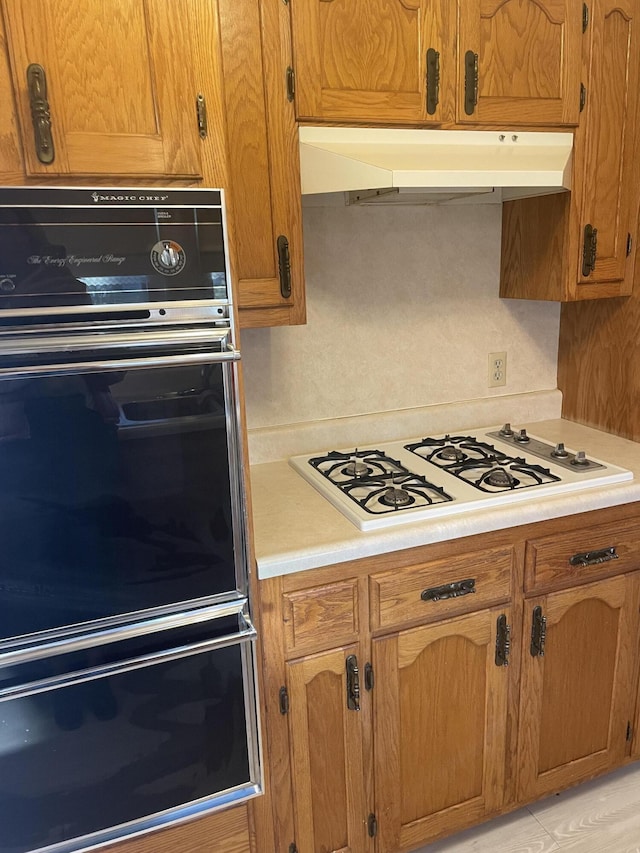 kitchen featuring double oven and white gas cooktop