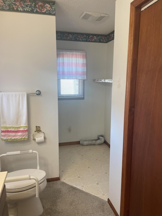 bathroom featuring vanity, a textured ceiling, and toilet