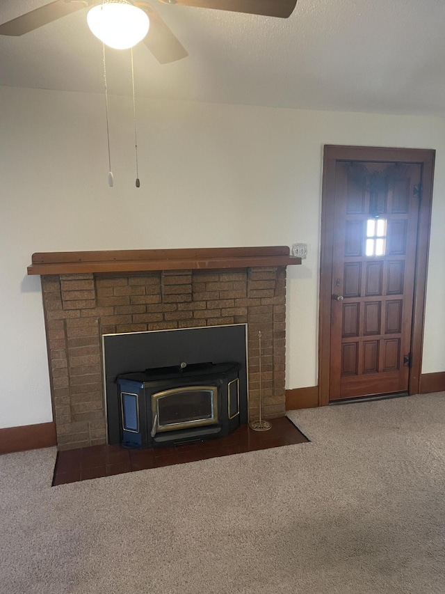 interior details with carpet floors, a wood stove, and ceiling fan