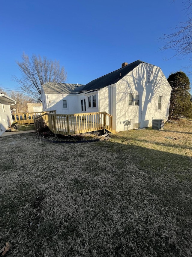 back of property featuring central AC unit, a yard, and a deck