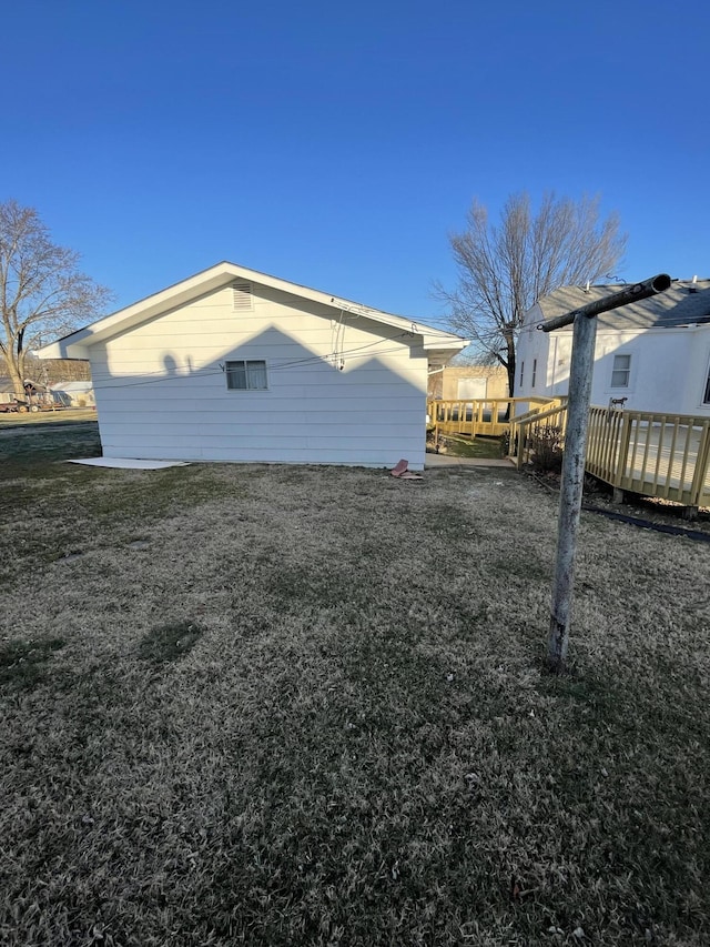 view of side of home with a yard and a deck