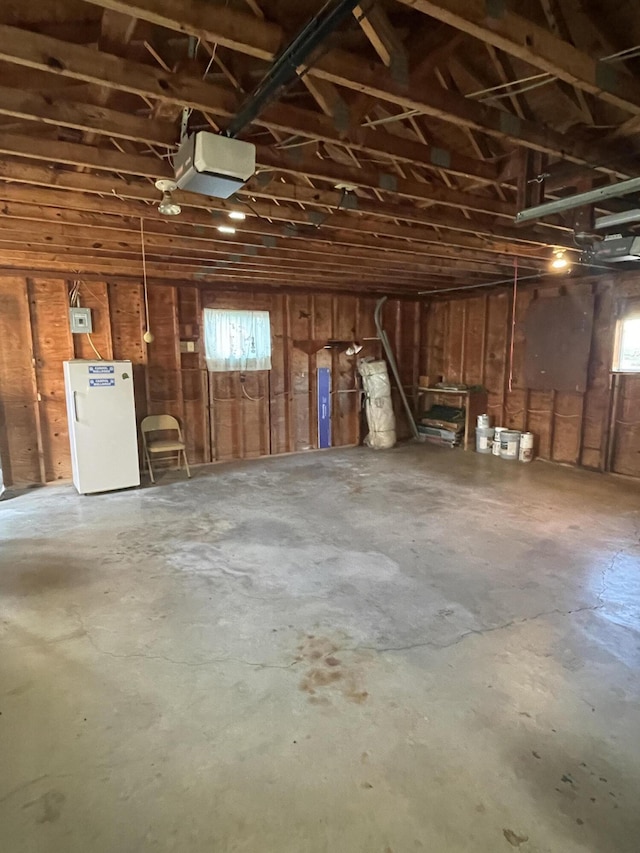 garage featuring white refrigerator and a garage door opener