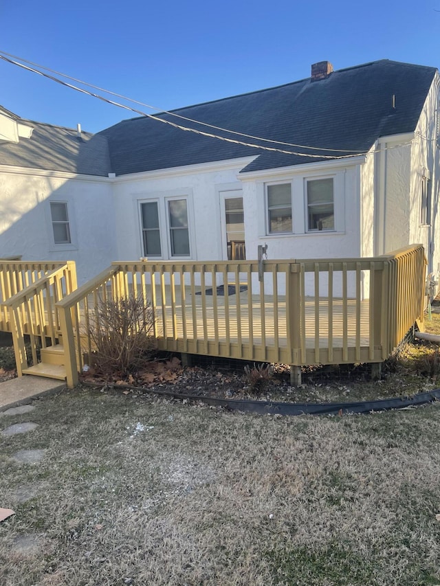 rear view of property featuring a wooden deck