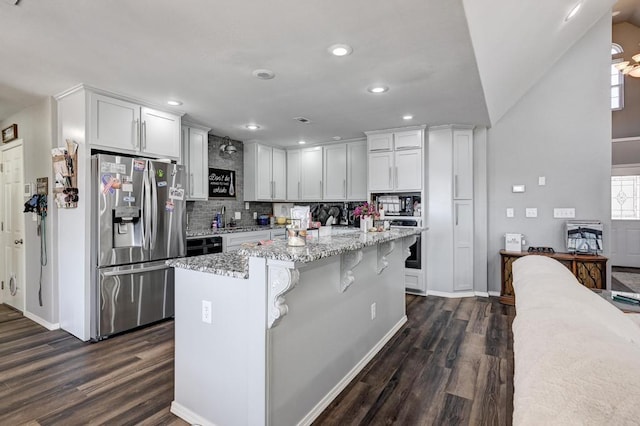21 Meadow Brook Ln, Anderson, MO 64831 - kitchen with light stone countertops, a kitchen breakfast bar, white cabinets, and appliances with stainless steel finishes