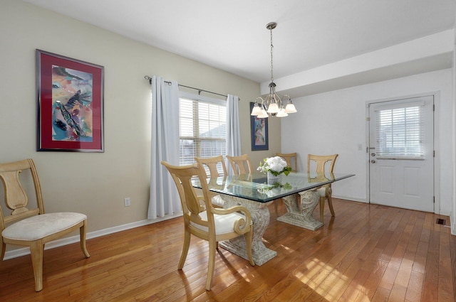 dining room with hardwood / wood-style flooring and a chandelier