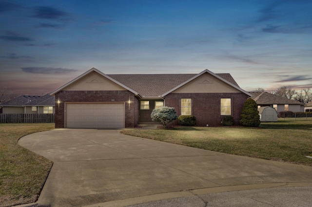 ranch-style home featuring a garage and a lawn