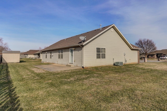 rear view of property featuring a storage shed, cooling unit, a lawn, and a patio area