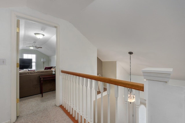 hall with vaulted ceiling and carpet