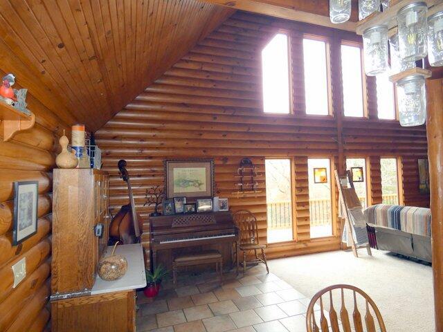 living room with wood ceiling, rustic walls, and high vaulted ceiling