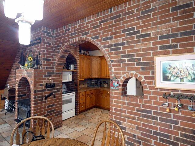 kitchen featuring brick wall, white electric range oven, and wooden ceiling