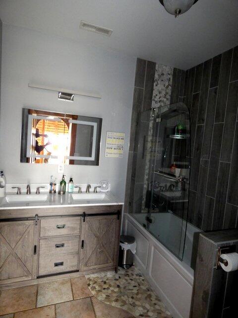 bathroom with vanity and combined bath / shower with glass door