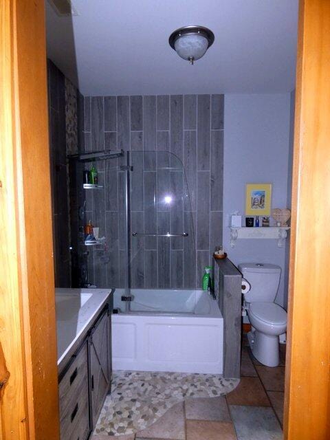 full bathroom featuring tiled shower / bath, vanity, toilet, and tile patterned floors