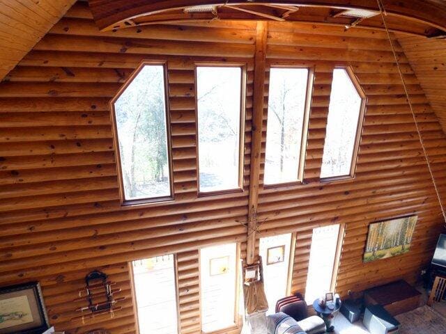 living room with log walls and high vaulted ceiling