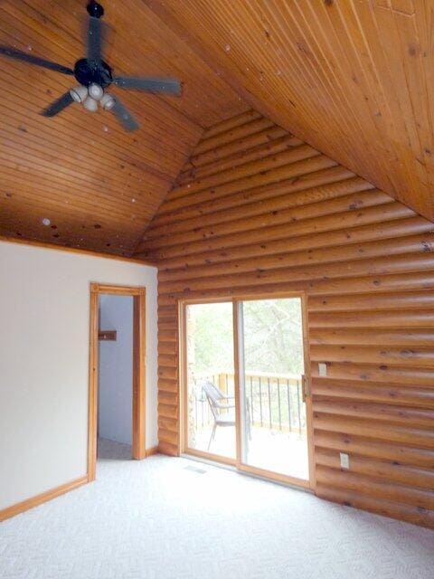 unfurnished living room featuring high vaulted ceiling, light colored carpet, rustic walls, and wood ceiling