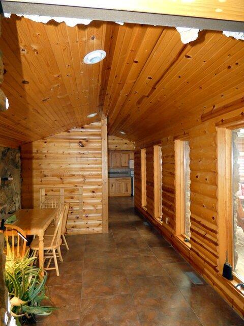 unfurnished dining area featuring wood ceiling, lofted ceiling, and rustic walls