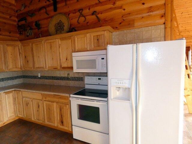 kitchen with tasteful backsplash and white appliances