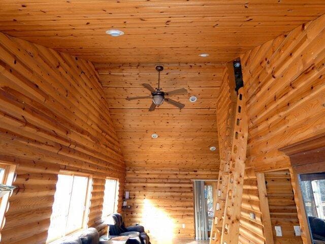 interior space featuring wood ceiling, ceiling fan, and rustic walls