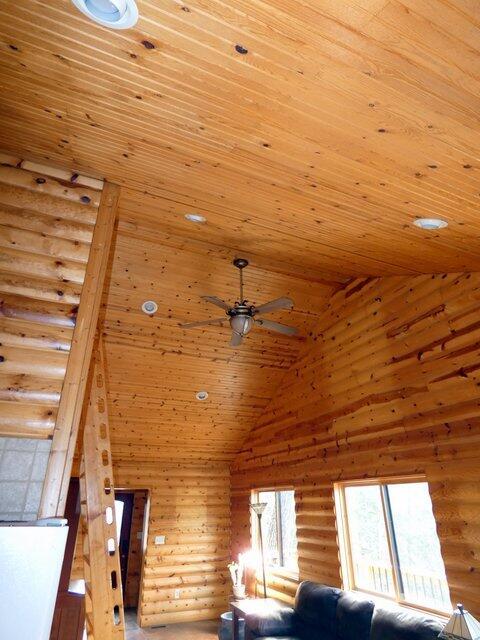 unfurnished living room with ceiling fan, high vaulted ceiling, log walls, and wood ceiling