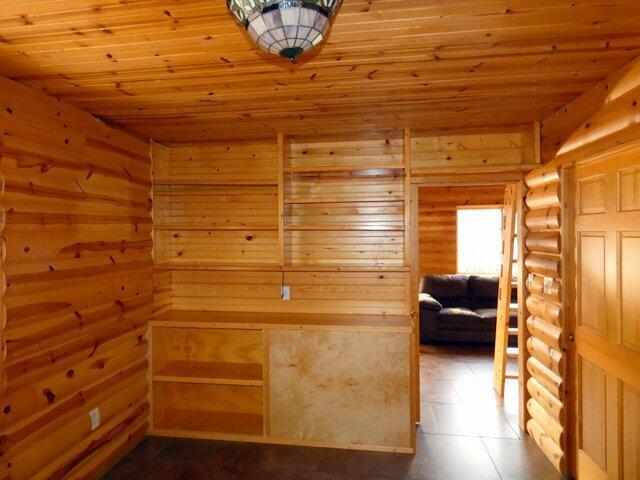 interior space featuring wooden ceiling and log walls