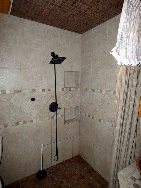 bathroom with brick ceiling, toilet, and a shower with shower curtain