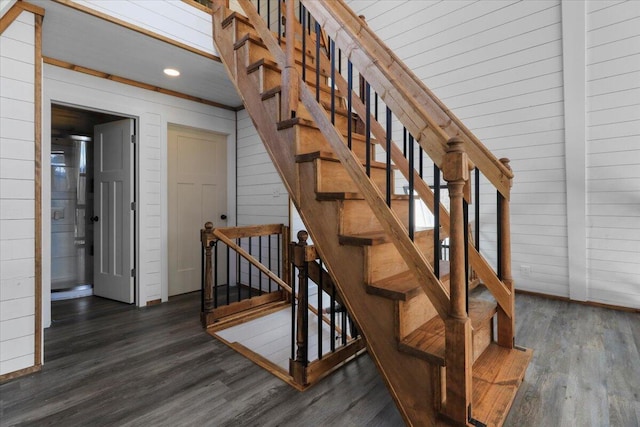 stairs featuring hardwood / wood-style flooring and wood walls