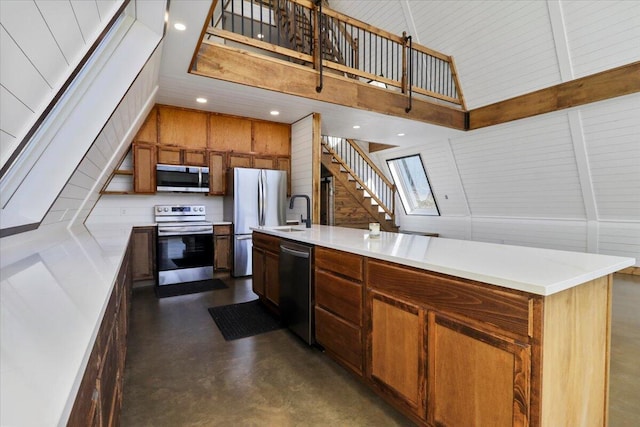 kitchen with sink, high vaulted ceiling, stainless steel appliances, a center island with sink, and wood walls