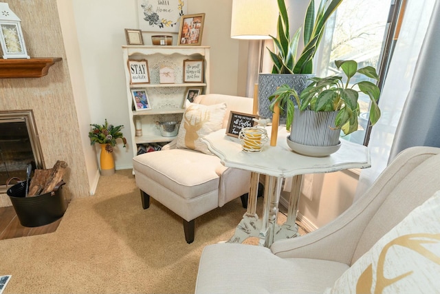 sitting room featuring a fireplace and carpet