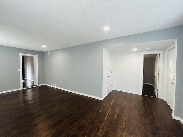 unfurnished room with dark hardwood / wood-style floors and a textured ceiling