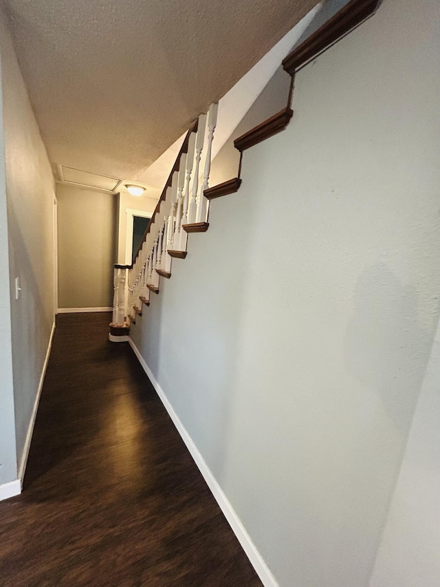 staircase with hardwood / wood-style floors and a textured ceiling