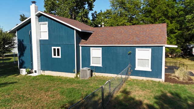 exterior space with central AC and a lawn