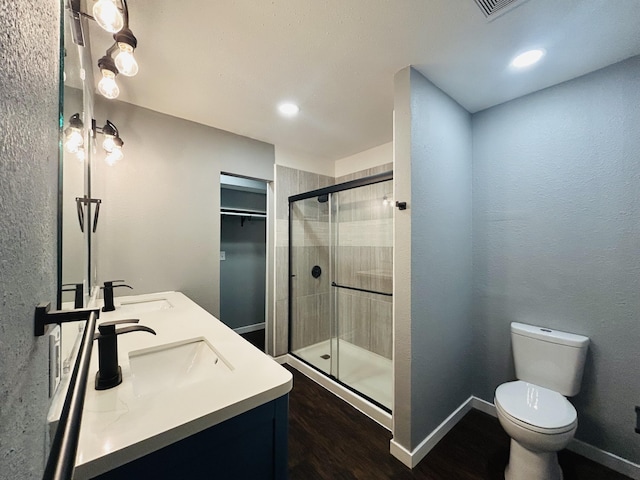 bathroom with vanity, toilet, and a shower with shower door