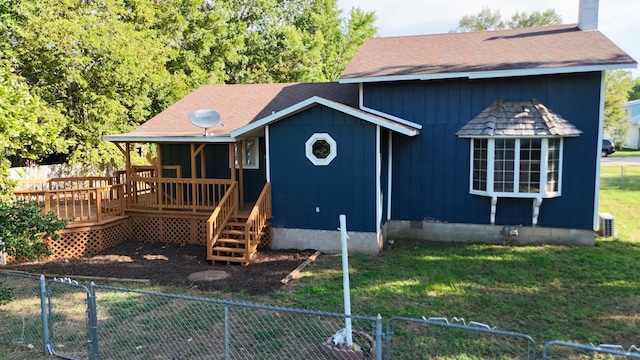 view of front of home with a wooden deck and a front lawn