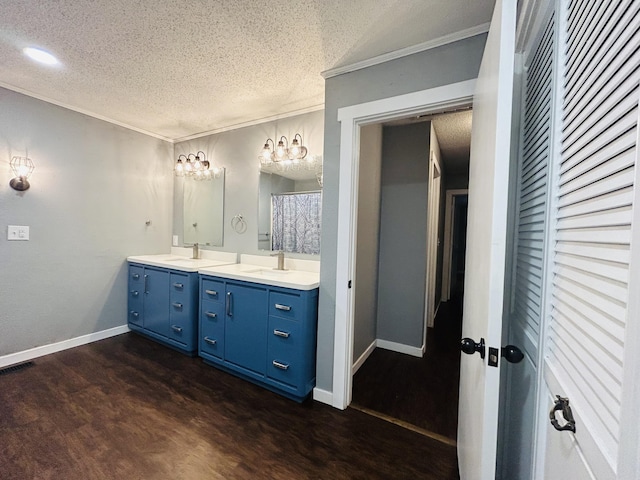 bathroom featuring ornamental molding, hardwood / wood-style floors, a textured ceiling, and vanity