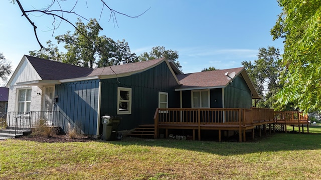 rear view of property with a wooden deck and a yard