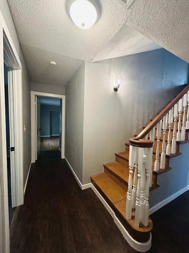 stairs featuring hardwood / wood-style floors and a textured ceiling