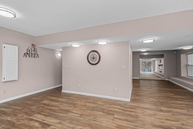 spare room with dark hardwood / wood-style flooring and a textured ceiling