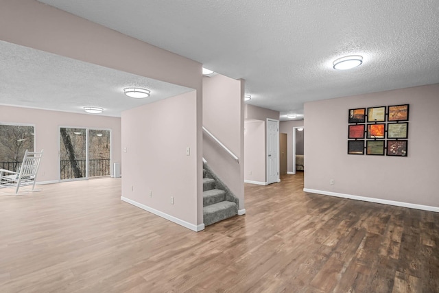 basement featuring hardwood / wood-style floors and a textured ceiling