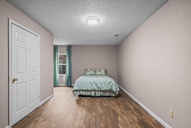 unfurnished bedroom with hardwood / wood-style flooring and a textured ceiling