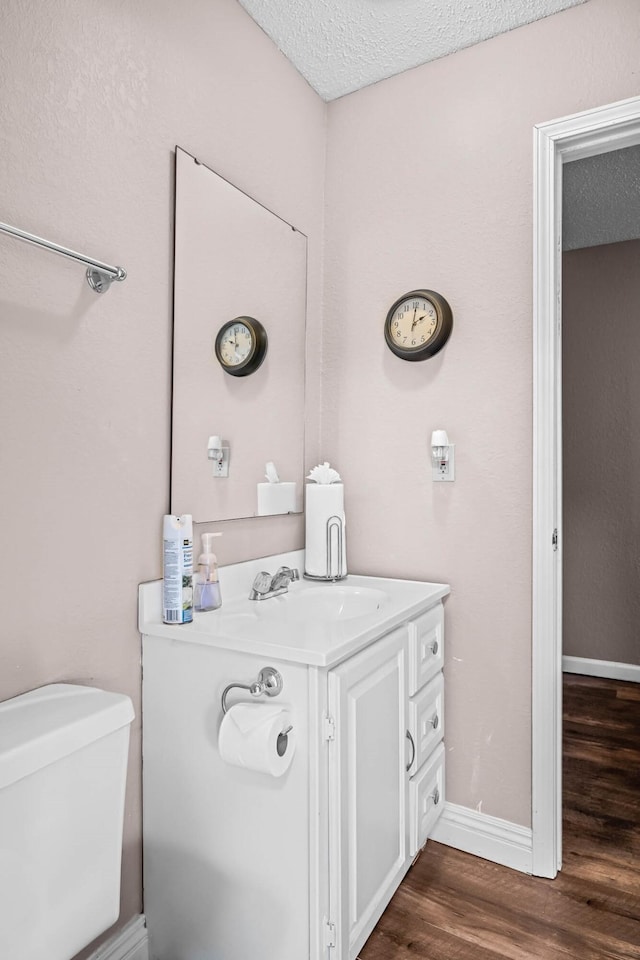 bathroom with vanity, hardwood / wood-style floors, a textured ceiling, and toilet