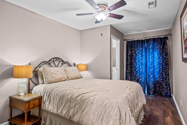 bedroom featuring ceiling fan, dark hardwood / wood-style flooring, and a textured ceiling