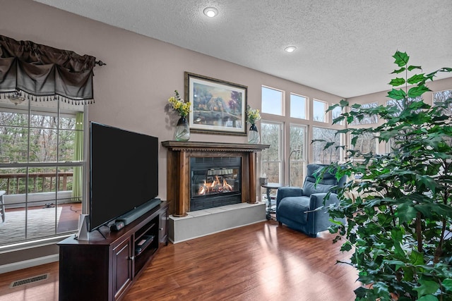 living area with hardwood / wood-style floors, a fireplace, and a textured ceiling