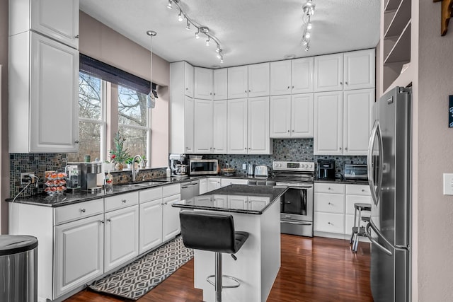 kitchen with white cabinetry, stainless steel appliances, and a center island