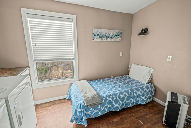 bedroom with separate washer and dryer, hardwood / wood-style floors, multiple windows, and heating unit